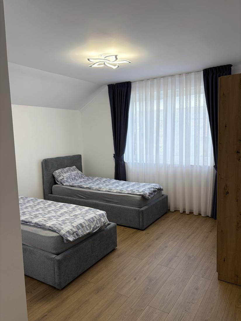 Cameră cu două paturi single lângă fereastră