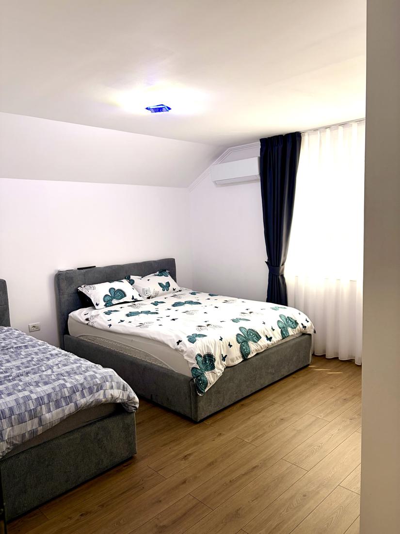 Cameră cu pat matrimonial cu lenjerie cu fluturi și un pat single